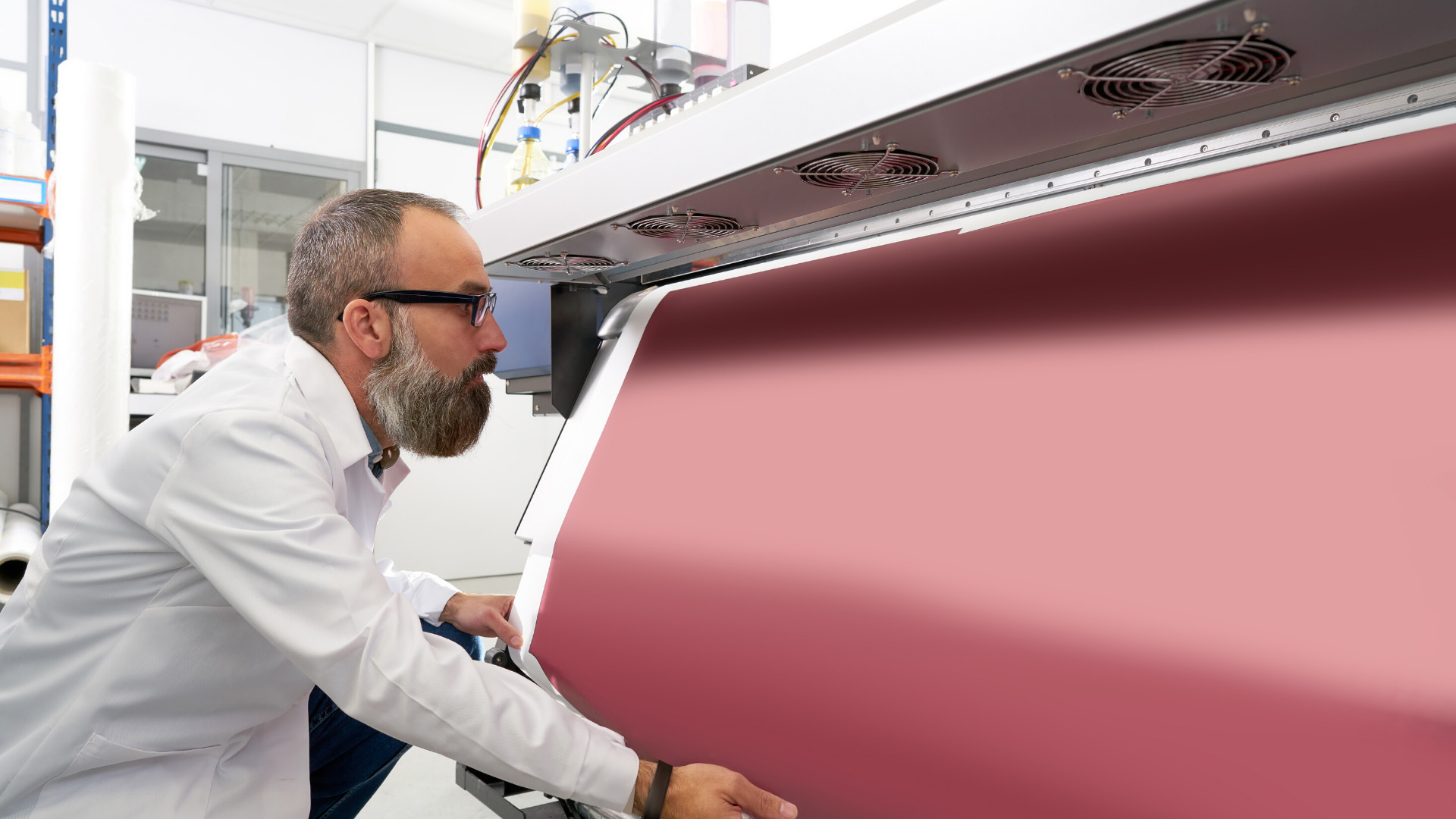 Man using a printer blanket coating machine for large scale printing