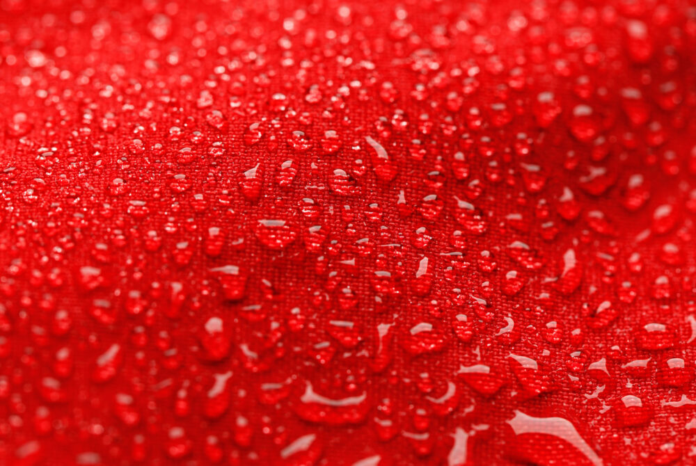 Red waterproof textile with water droplets on the surface