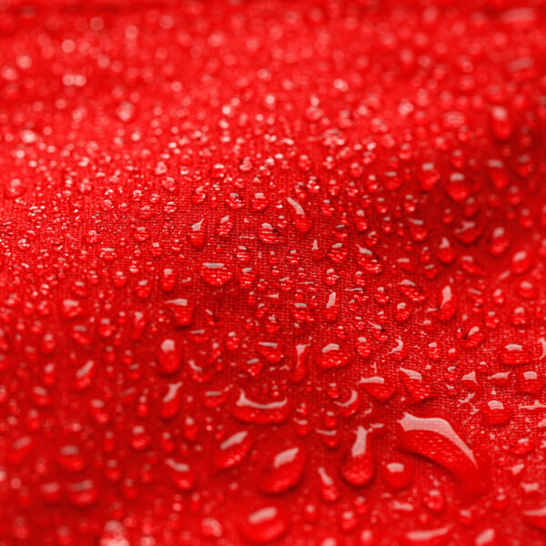Red waterproof textile with water droplets on the surface