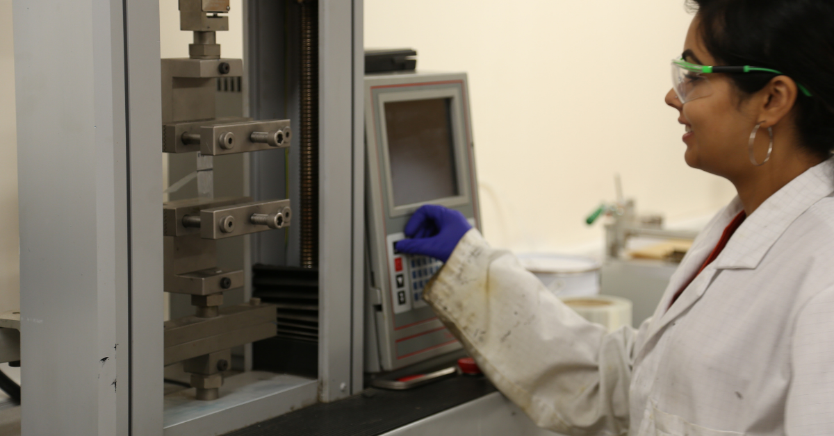 Lab assistant using adhesive tensile testing equipment