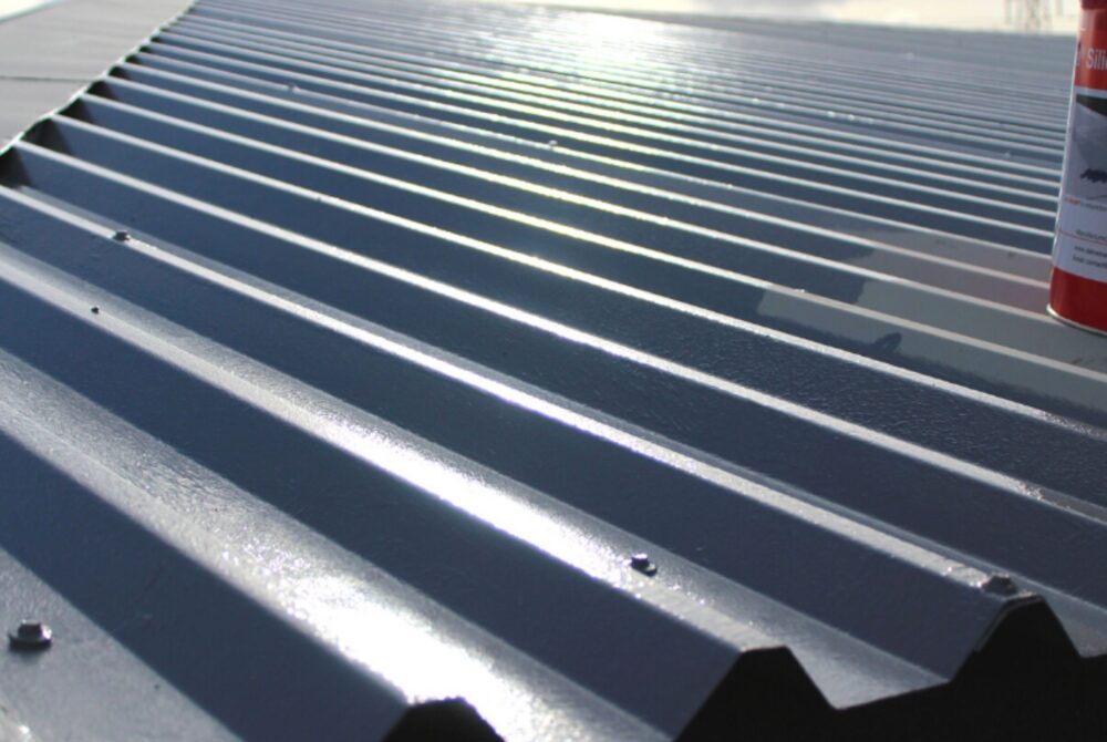 Image of a newly coated metal roof with a red tin