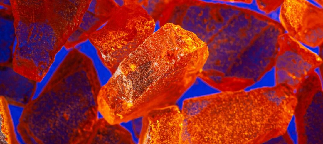 Abstract image of coating application particles as if seen under a microscope. Orange and red.