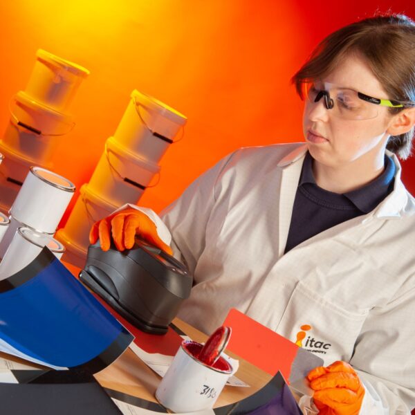 Female laboratory chemist doing colour testing on coating material.