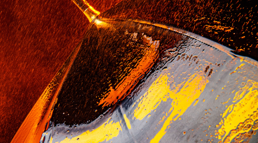 Orange, yellow and black umbrella with rain droplets on its surface.